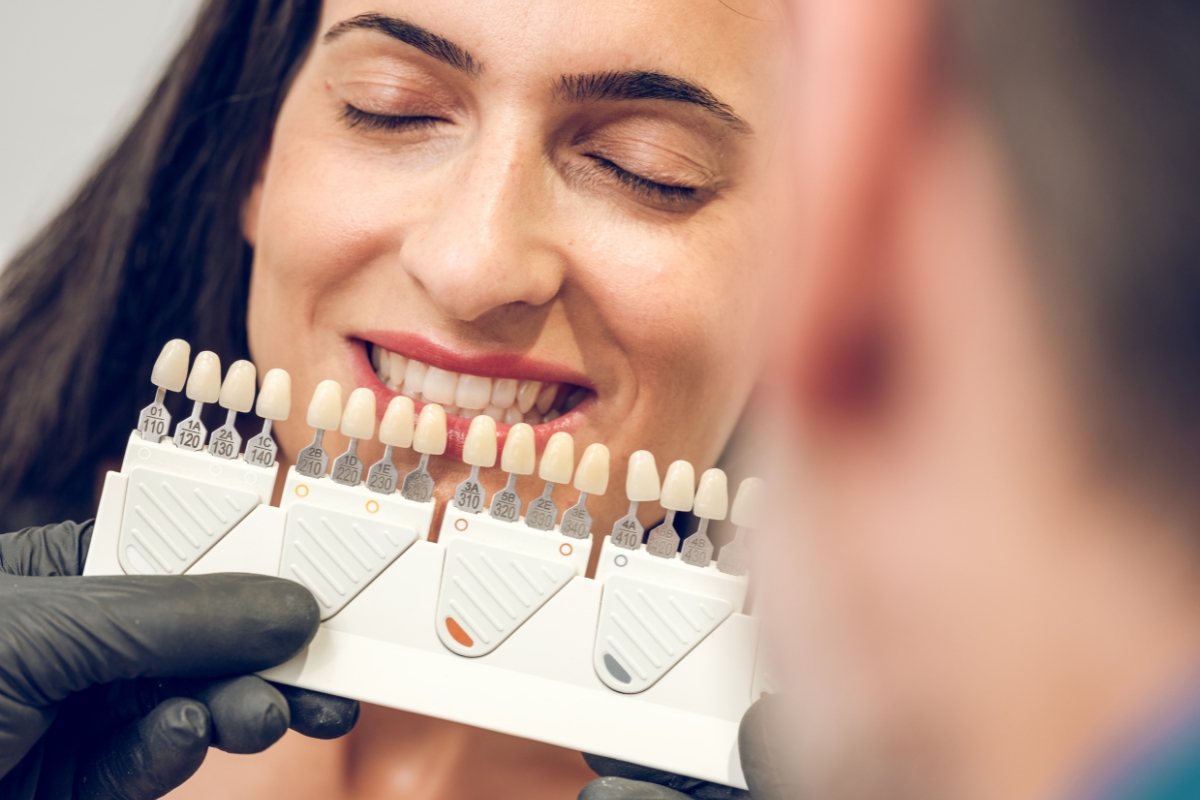Woman selecting veneer shade guide for natural smile makeover results